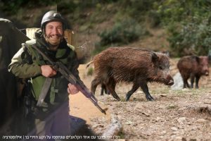 רס"ן יוסי פרבר עם אחד הרובים שנתפסו על רקע חזירי בר | אילוסטרציה